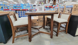 a 5 piece dining set displayed, includes a table and 4 padded chairs