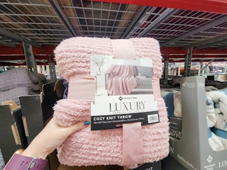 hand holding a pink luxury throw blanket