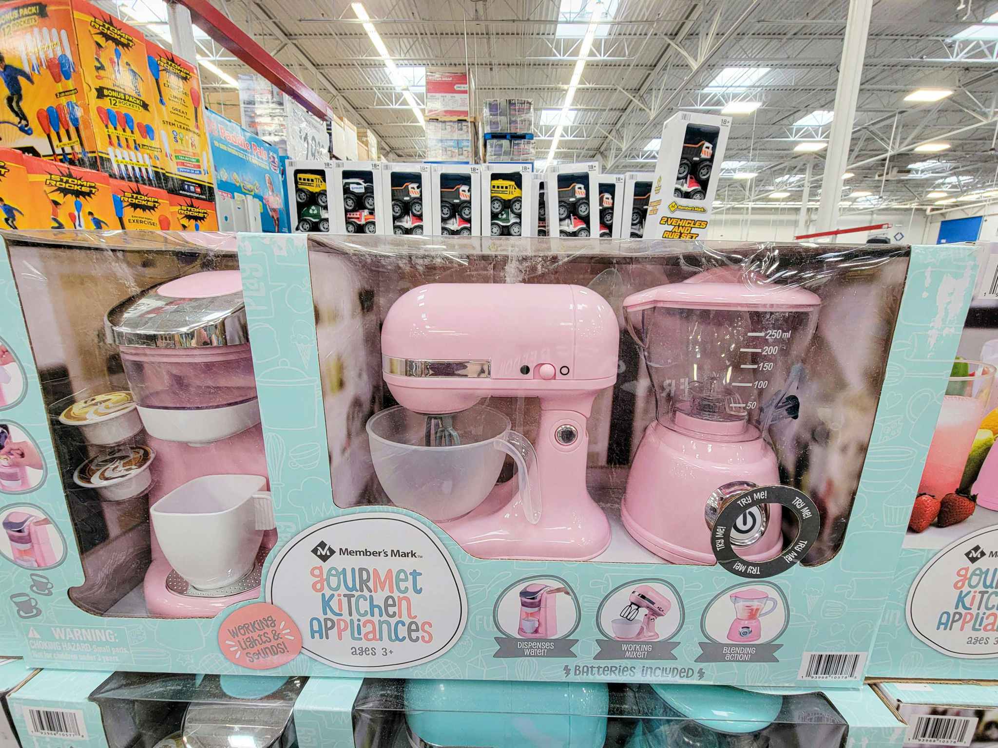 a set of pink toy kitchen appliances including a mixer, blender, and coffee maker