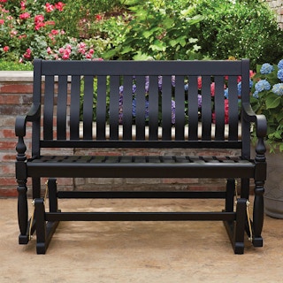 a wooden patio glider bench painted black