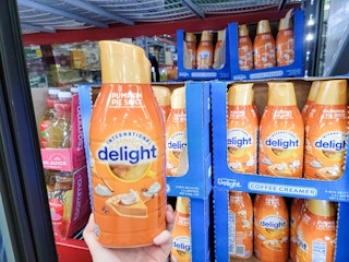 hand holding a bottle of international delight pumpkin spice coffee creamer
