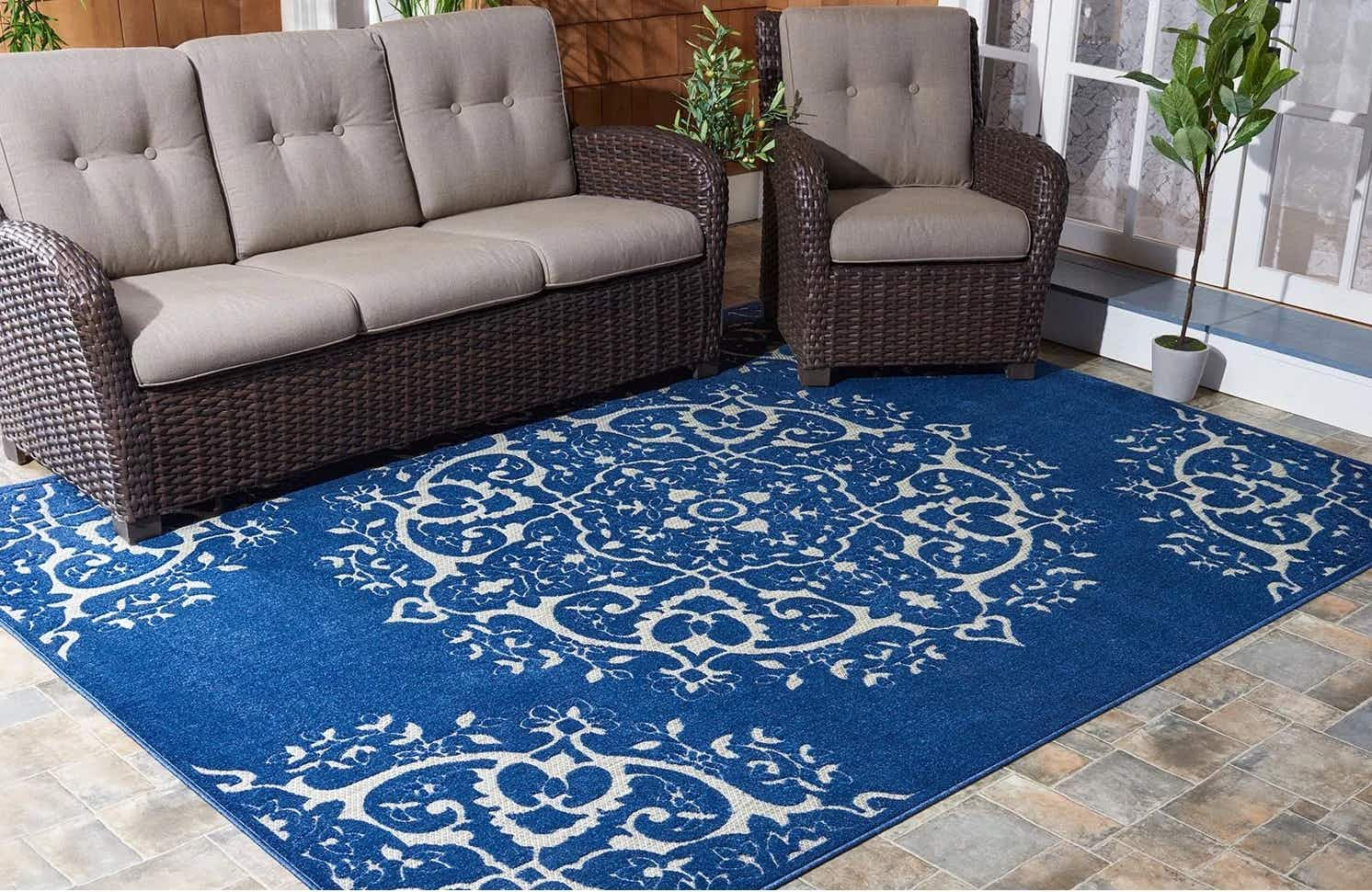 a patio with furniture and a blue 8 by 10 area rug with circular designs