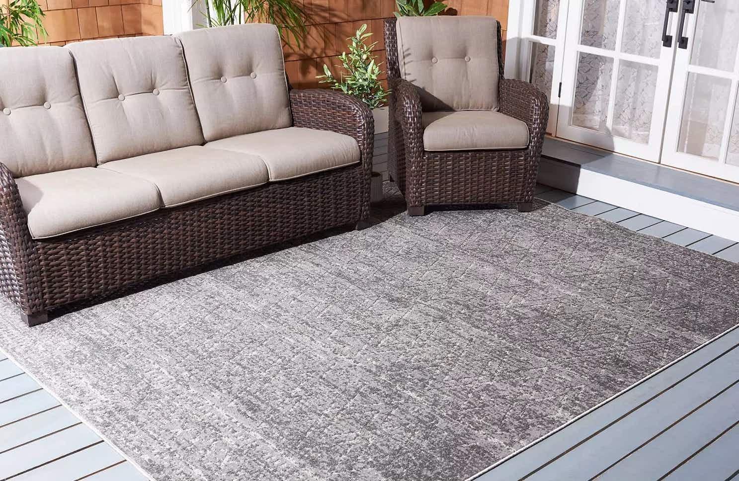 a patio with furniture on a grey 8 by 10 area rug