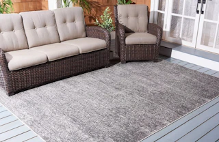 a patio with furniture on a grey 8 by 10 area rug