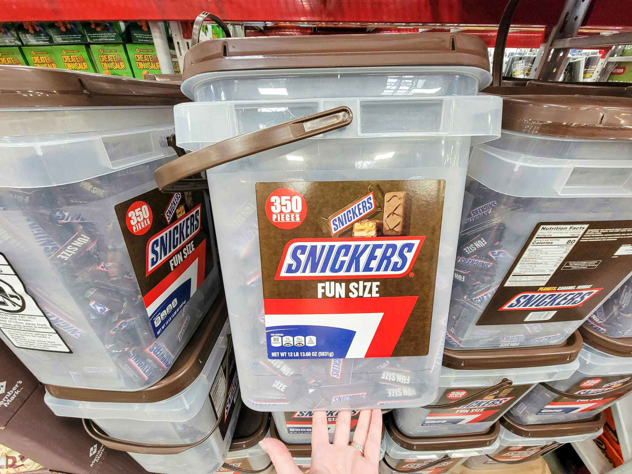 hand supporting a bucket of 350 snickers fun size candy bars