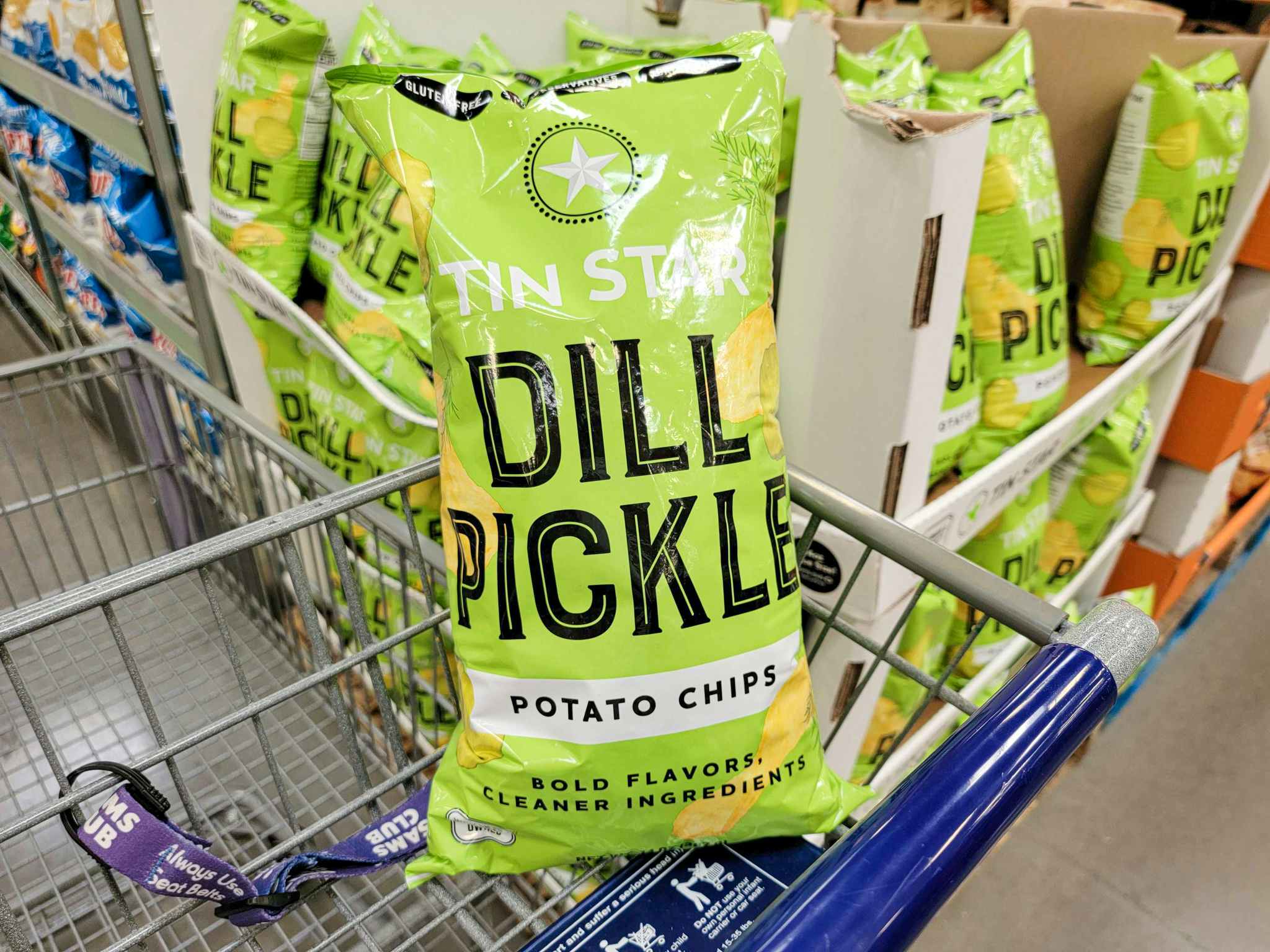 a bag of dill pickle flavored potato chips in a cart