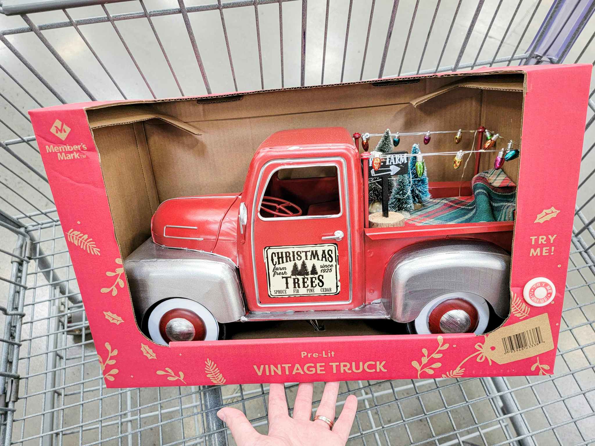 hand holding a vintage christmas truck decoration in a cart