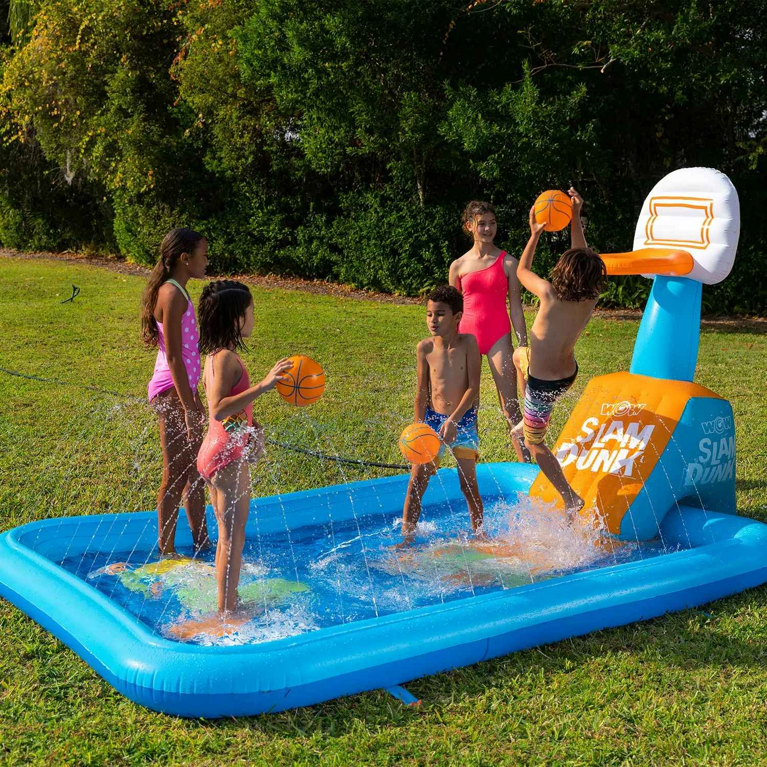 kids playing in an inflatable splash pad with a basketball hoop