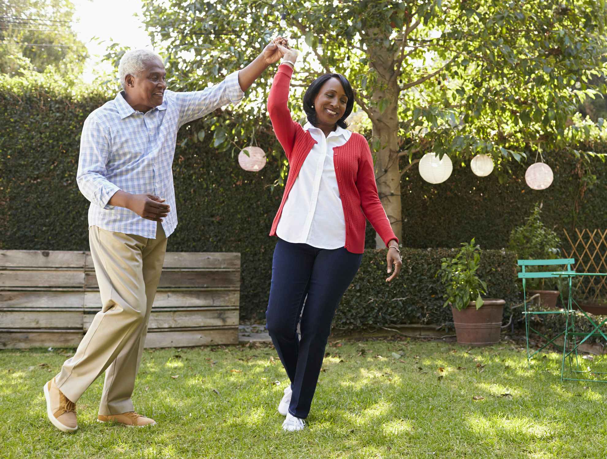 black senior couple dancing together in backyard