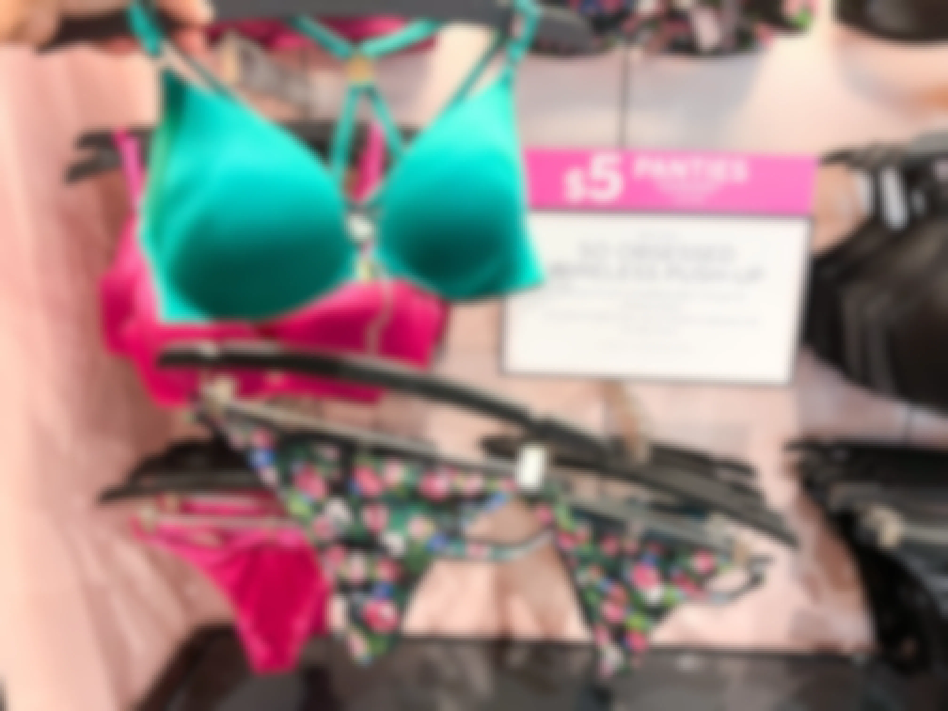 a green bra by a floral pair of panties by a sale sign