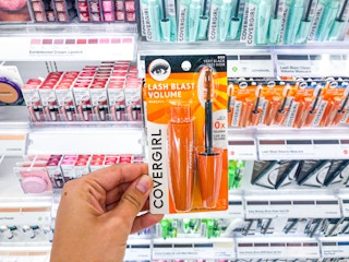 hand holding Covergirl Lashblast mascara in front of shelf
