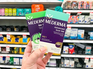 Mederma scar repair products with hand holding in front of Target shelf