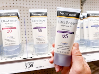 hand holding Neutrogena sunscreen in front of Target shelf with like items