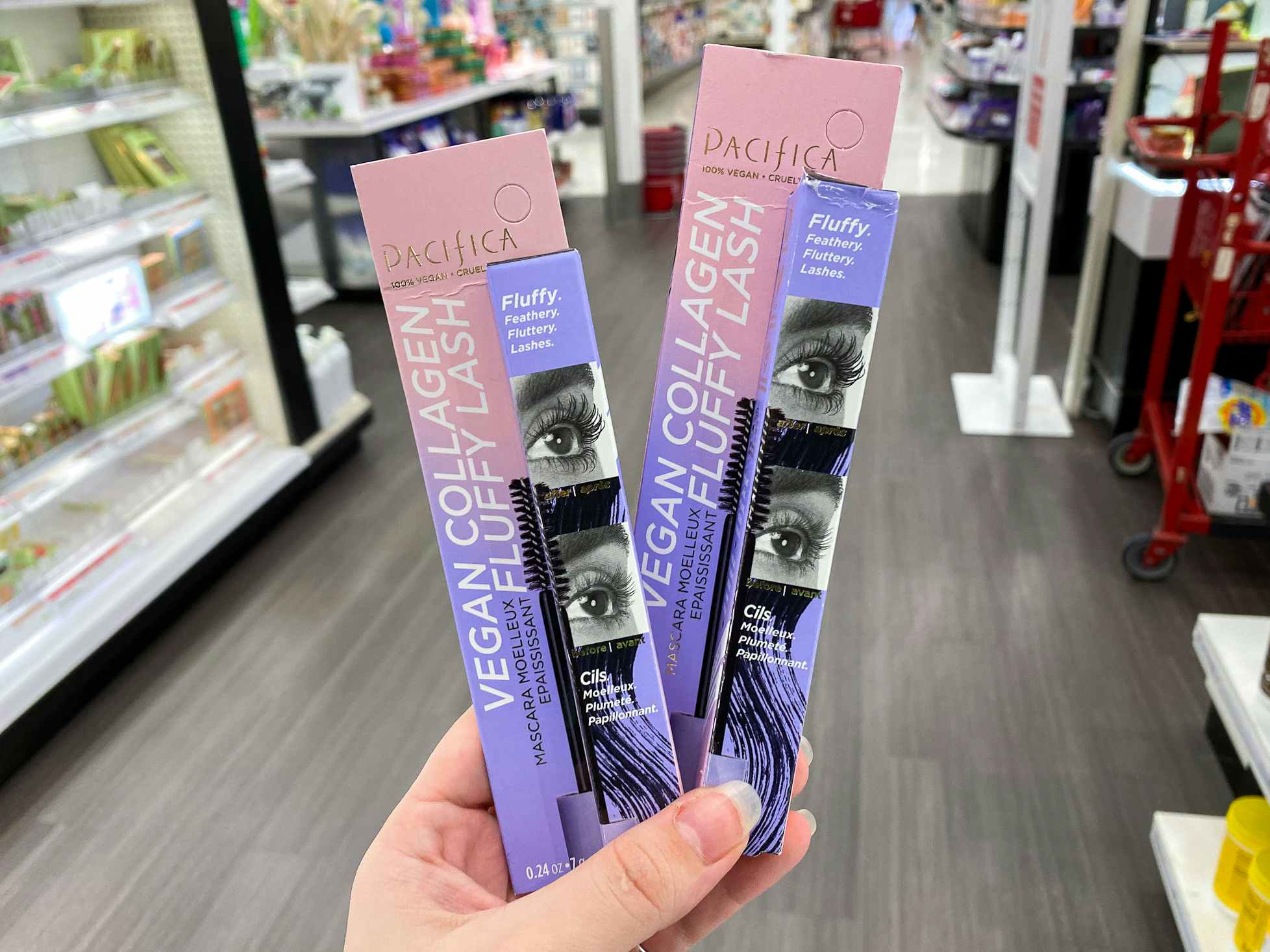 A person's hand holding two Pacifica Vegan Collagen Fluffy Lash Mascaras in a beauty aisle at Target.