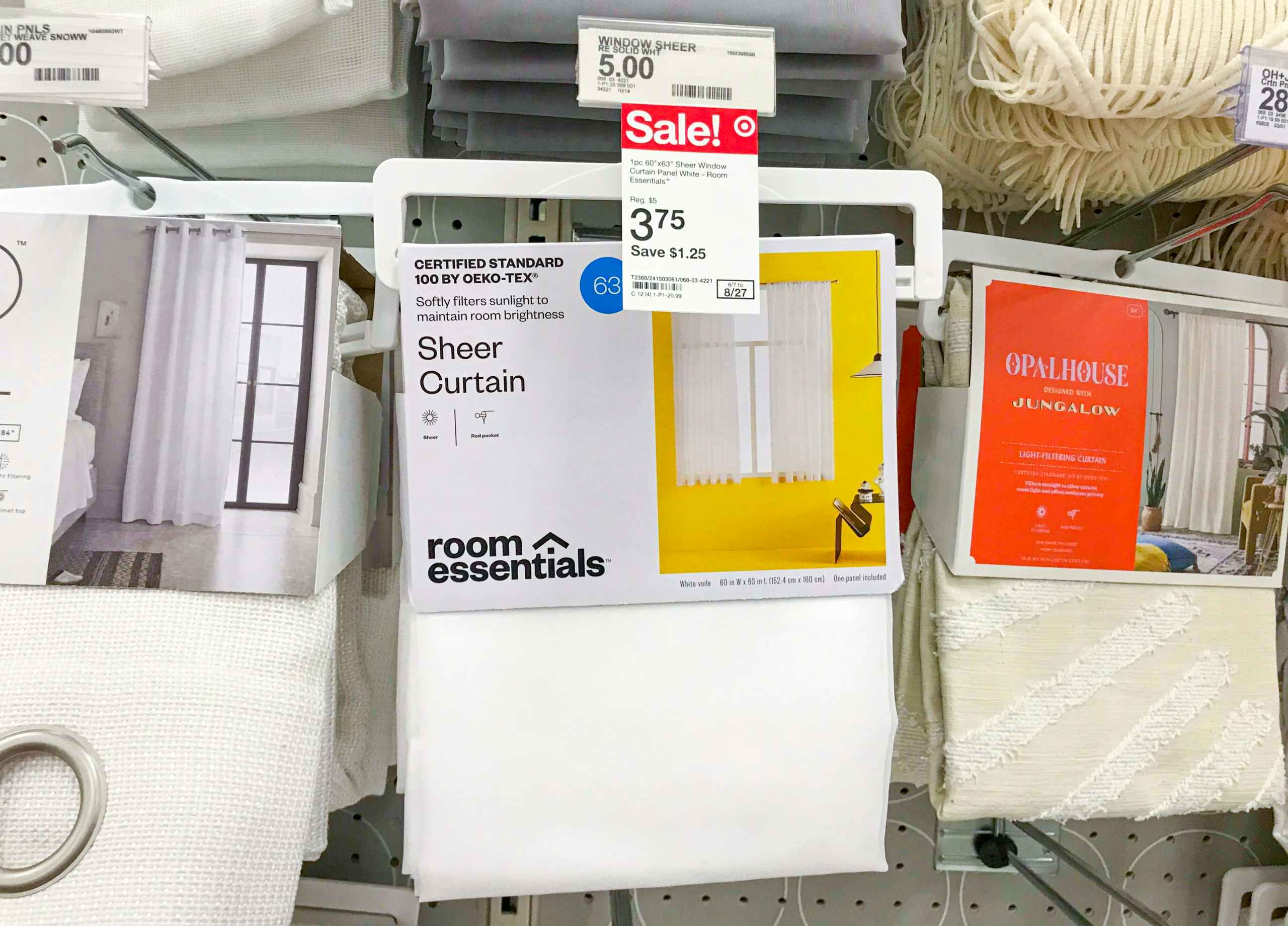 white Room Essentials sheer curtains on a Target shelf with sale price tag showing