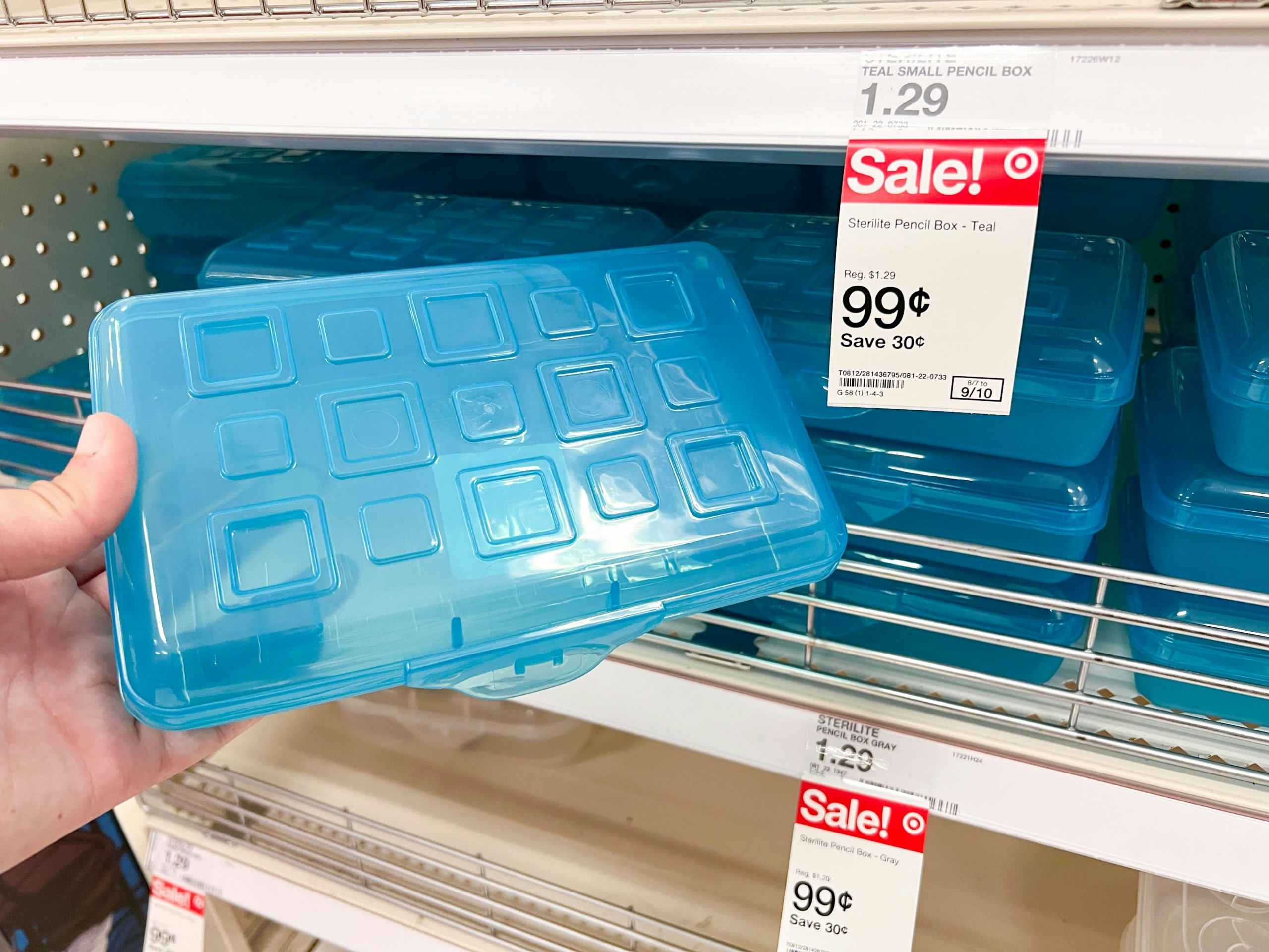 hand holding a blue Sterilite pencil box in front of a Target shelf with other pencil boxes and 99 cent sale price tag