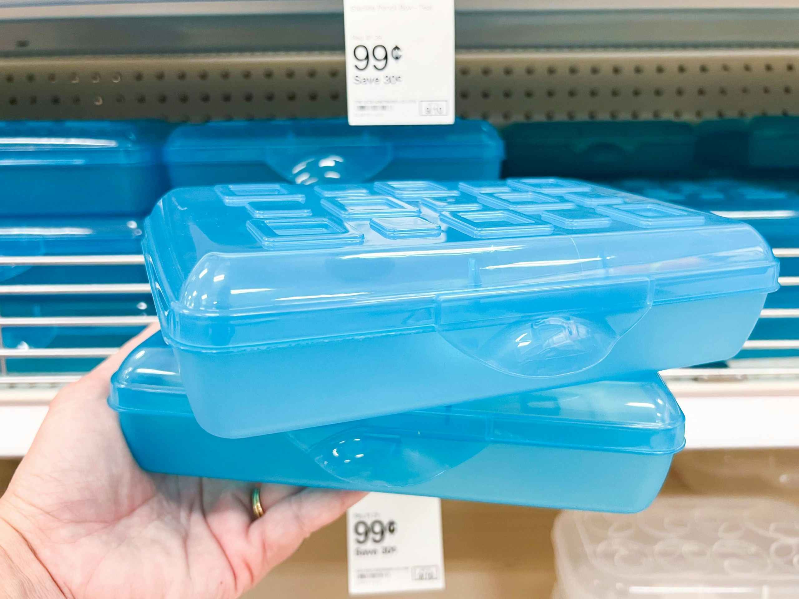 hand holding two blue Sterilite pencil boxes in front of Target shelf with the 99 cent sale price tag visible