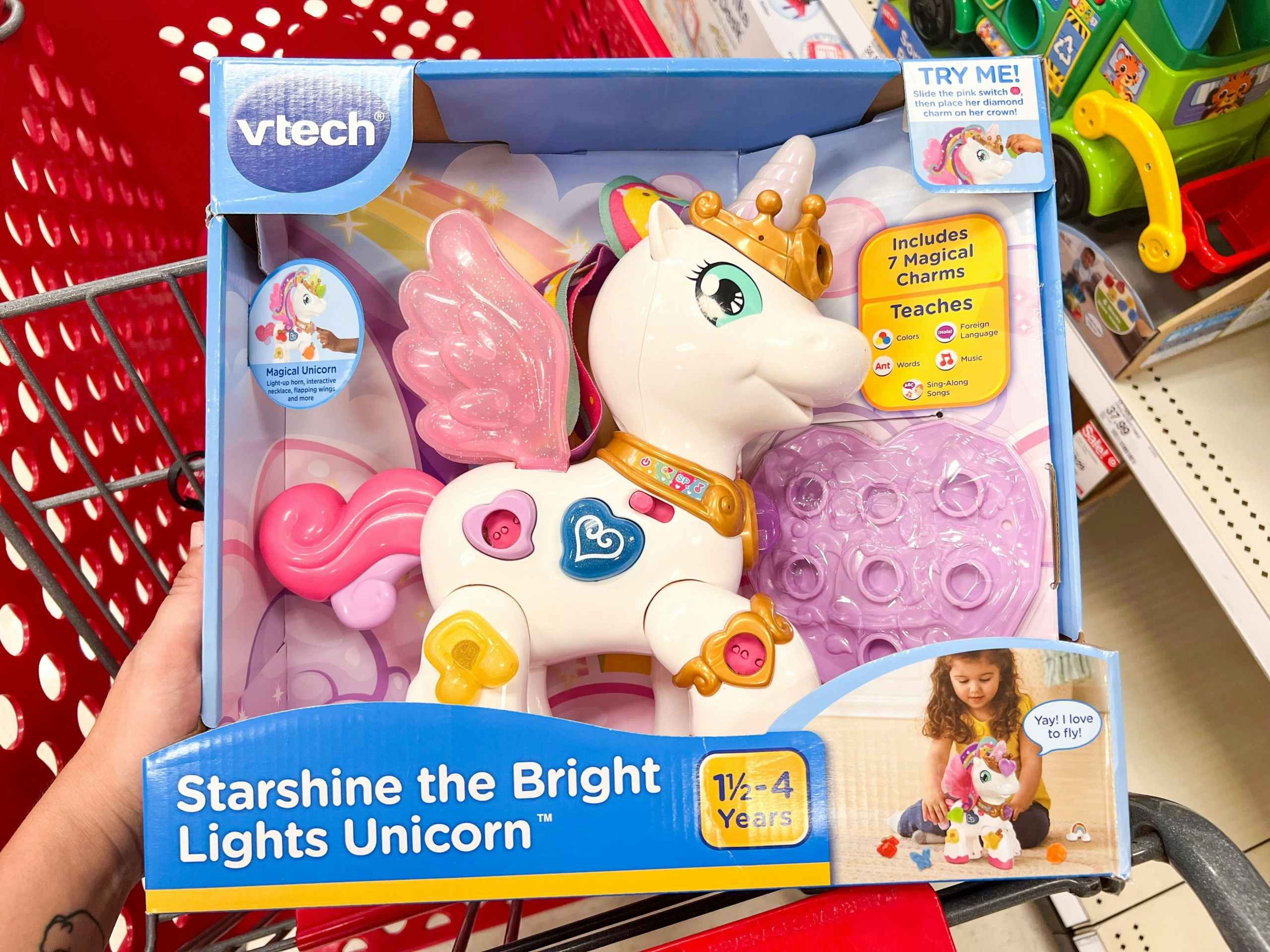 hand holding Vtech Unicorn in in the basket of a Target cart