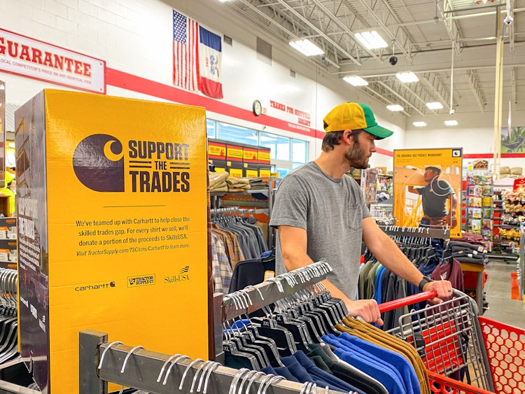 A man shopping in the men's apparel section of Tractor Supply.
