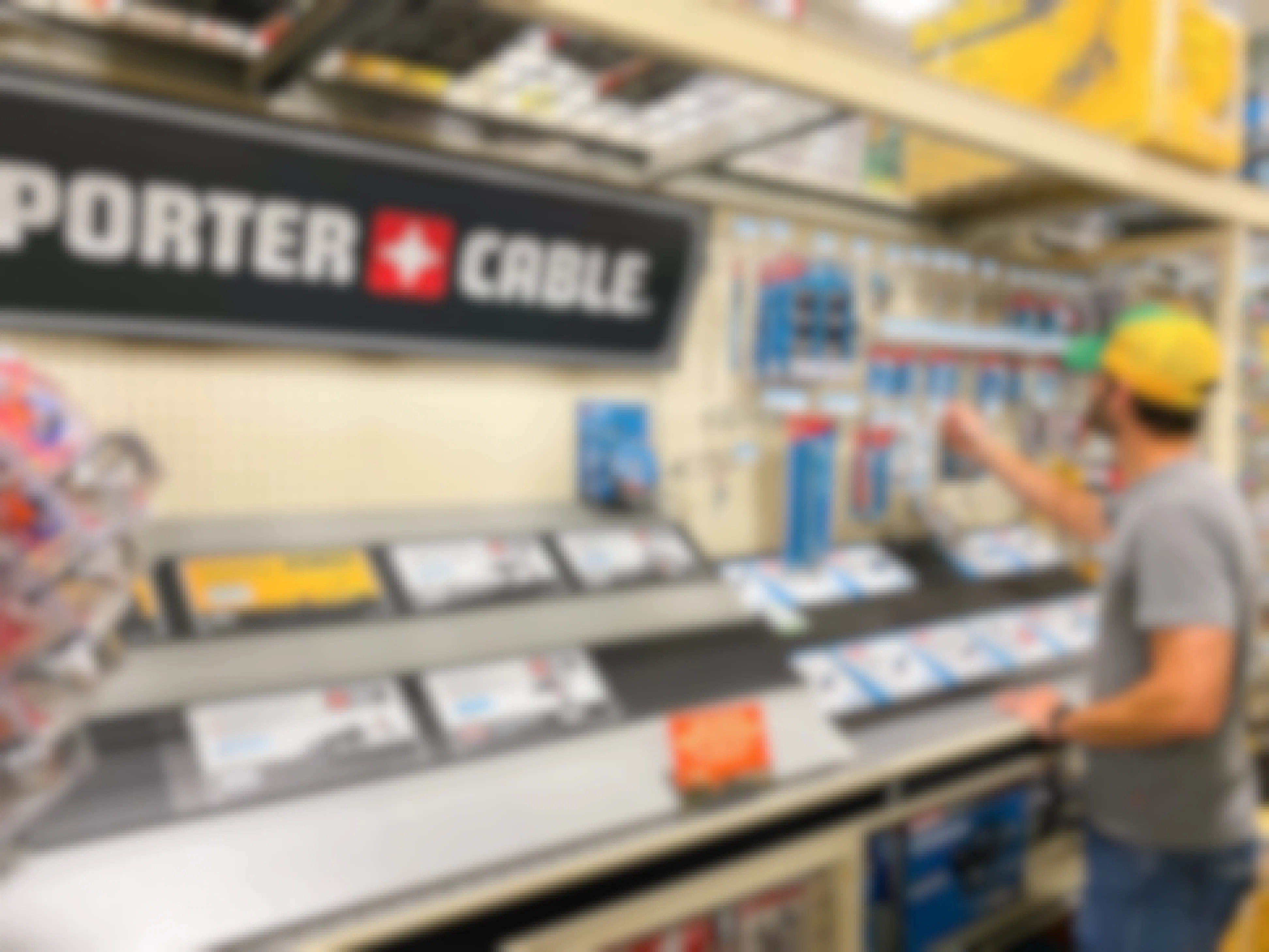 A man looking at items in the Porter Cable tool section of Tractor Supply.