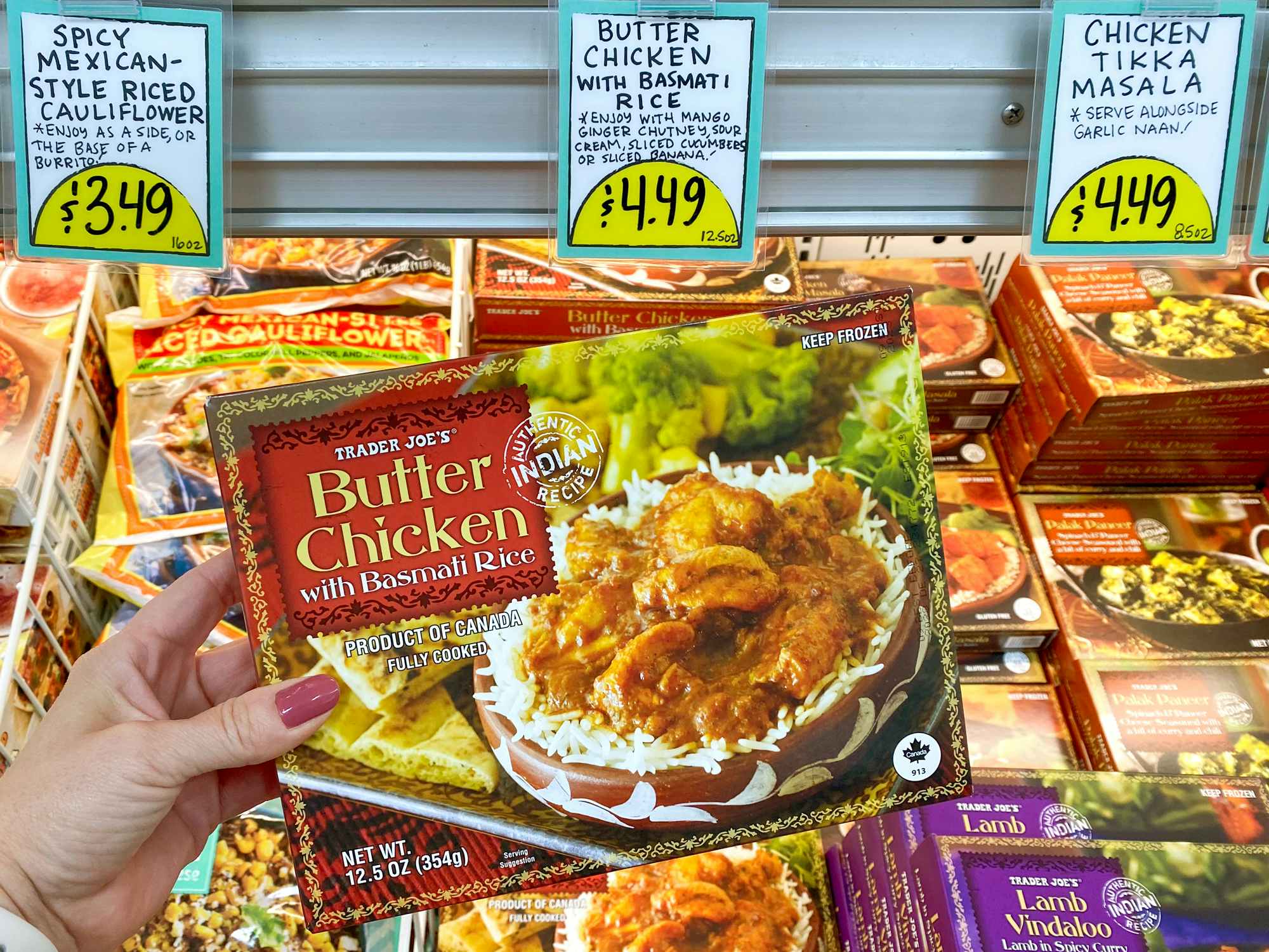 person holding butter chicken with basmati rice product in trader joes