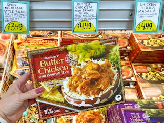 person holding butter chicken with basmati rice product in trader joes