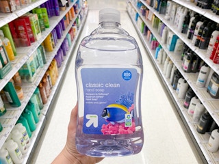hand holding up bottle of up and up soap in Target store aisle