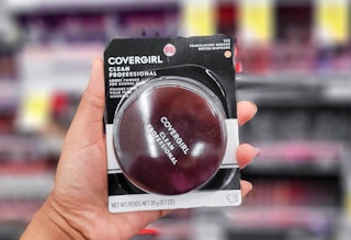 hand holding Covergirl powder in aisle