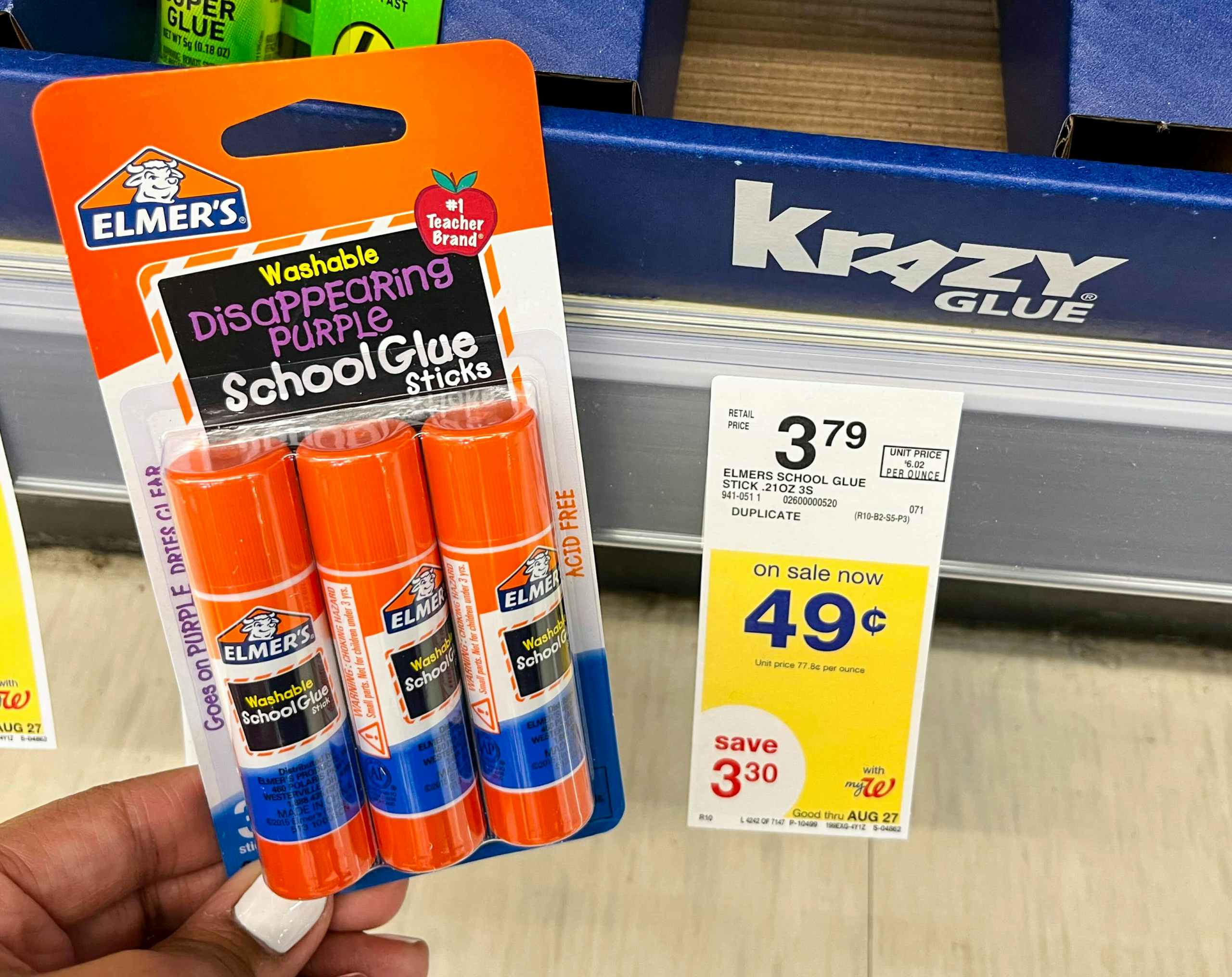 hand holding pack of Elmer's school glue sticks next to sales tag
