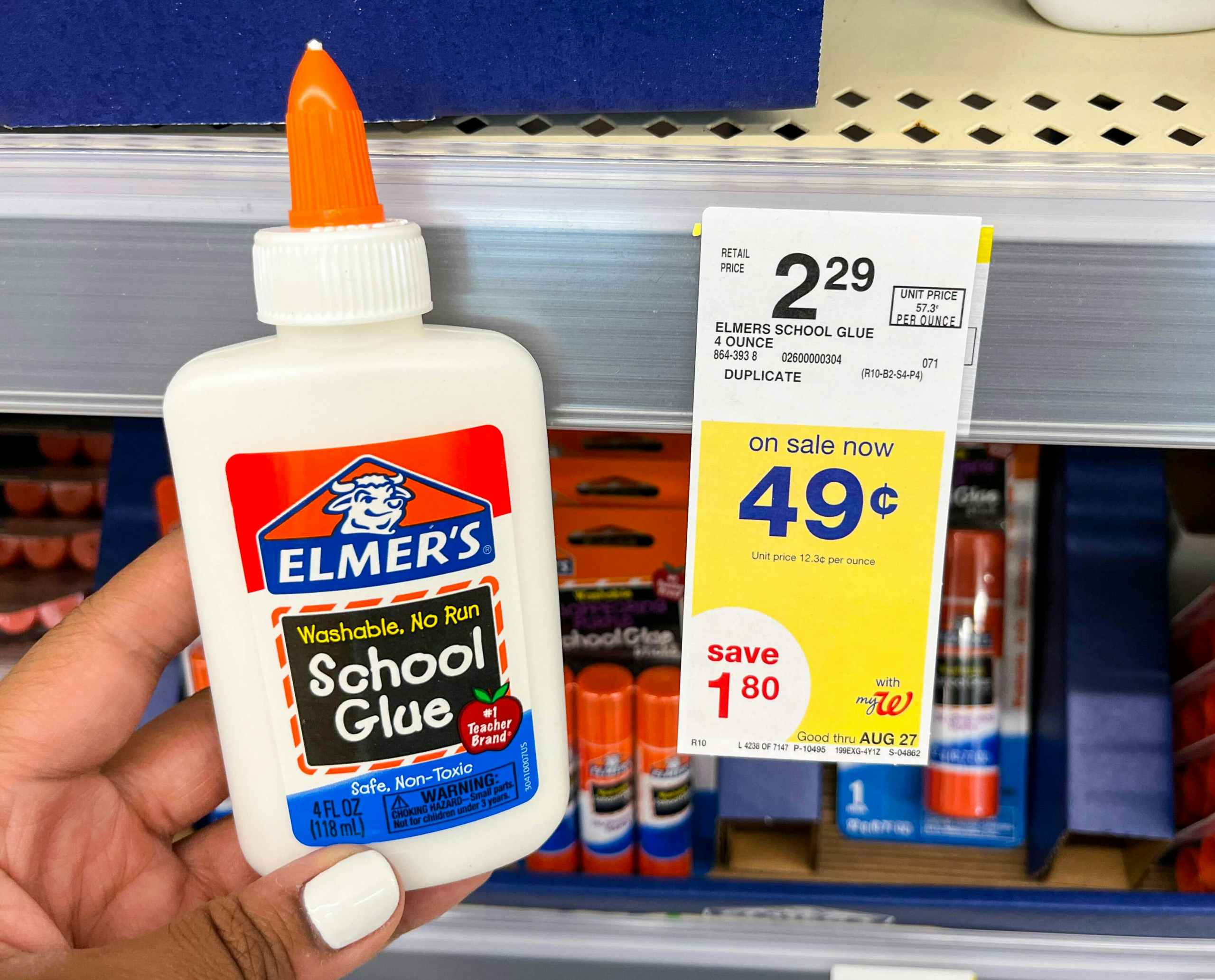 hand holding bottle of Elmer's school glue next to sales tag