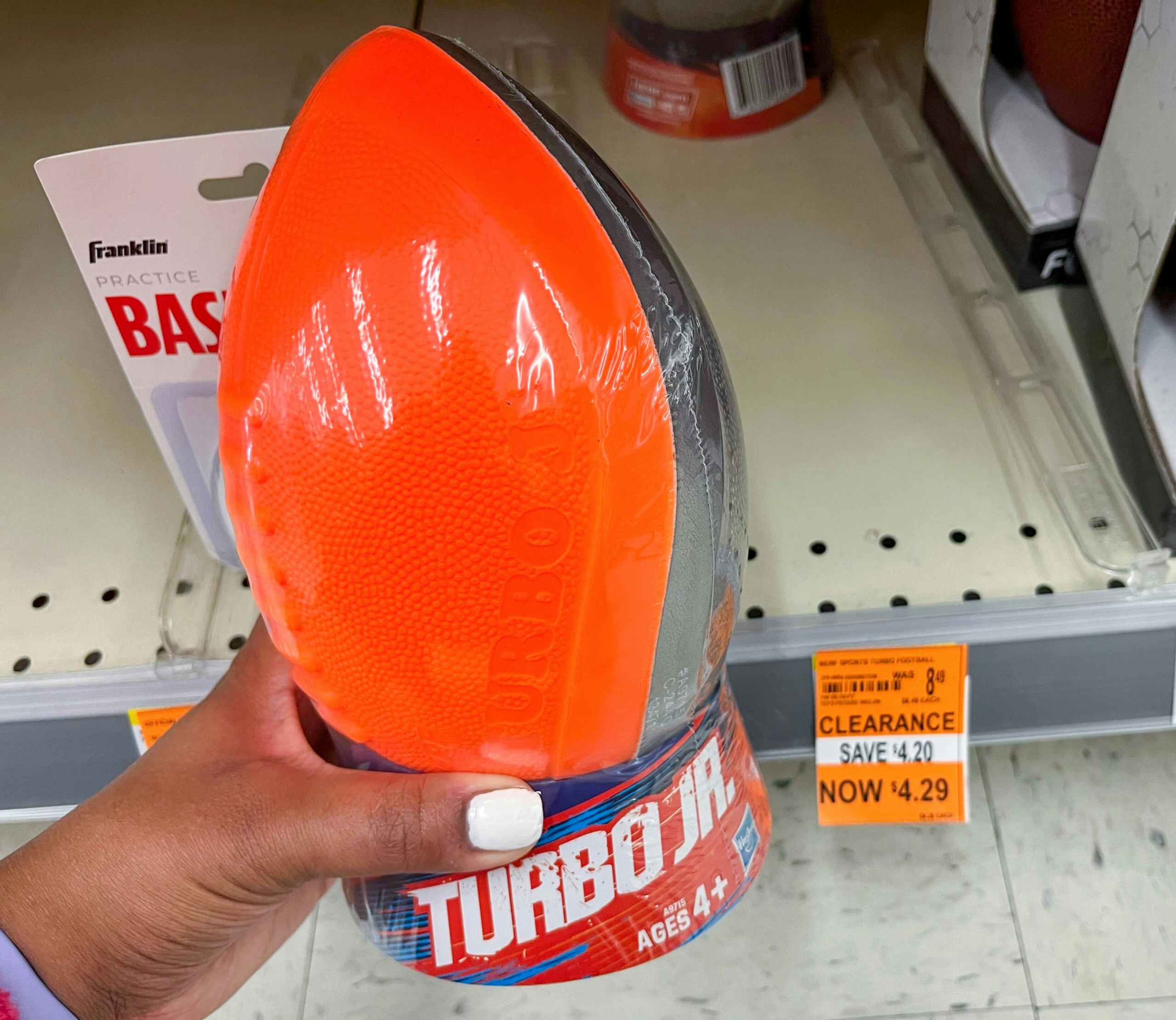hand holding Turbo Jr football next to clearance tag