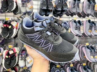 hand holding black avia trail sneakers at walmart