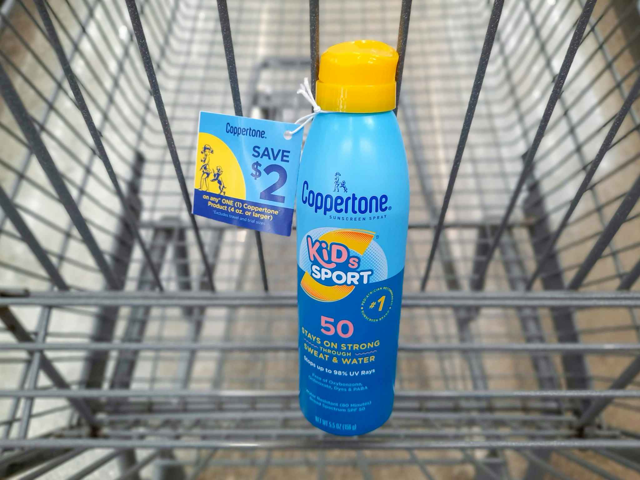 Coppertone Kids Sport Sunscreen product in Walmart shopping cart. A $2 hangtag coupon is attached to the product.