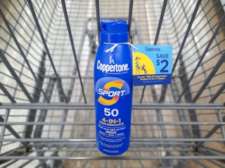 Coppertone Sport Sunscreen product in Walmart shopping cart. A $2 hangtag coupon is attached to the product.