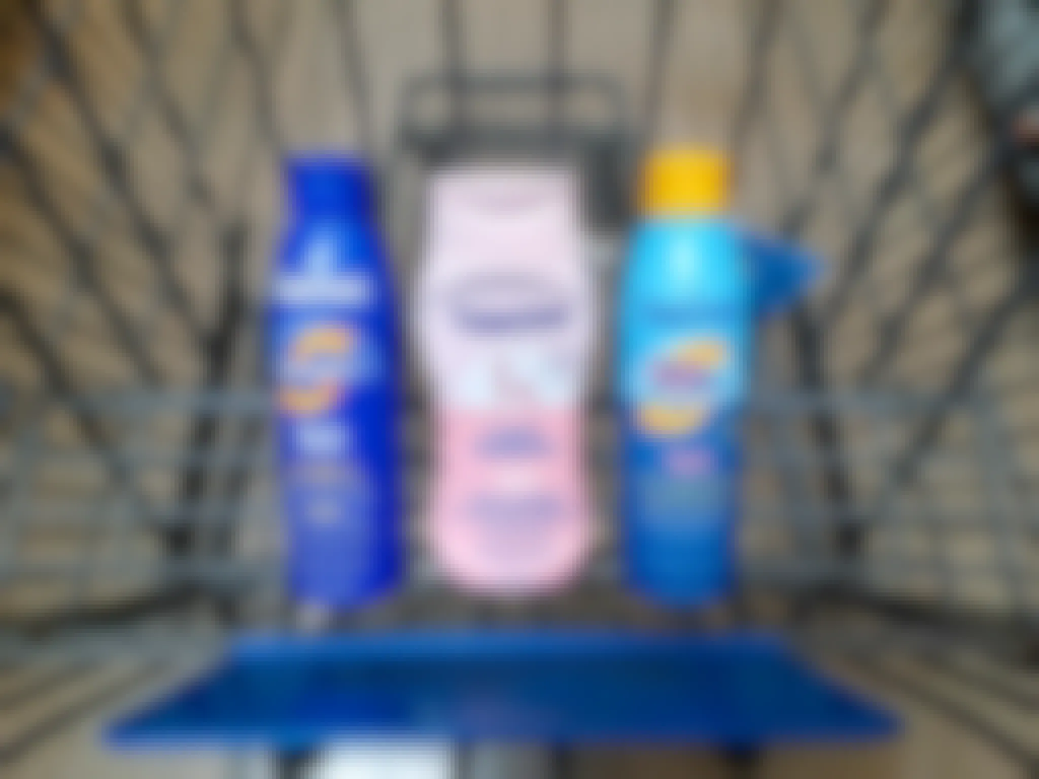 Three Coppertone Sunscreen products in Walmart shopping cart. Each product has a $2 hang tag coupon attached.