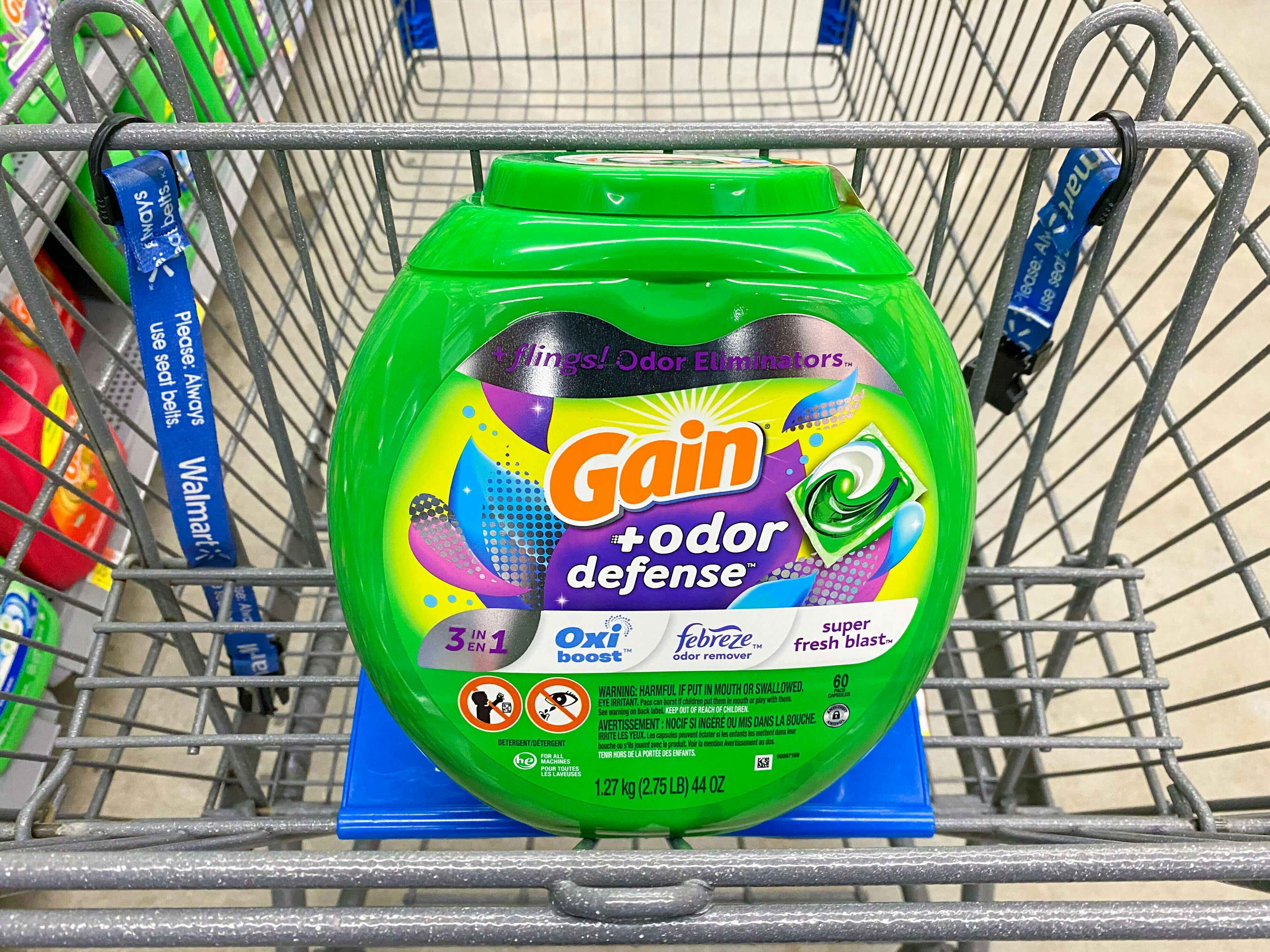 A bottle of Gain Flings Laundry Detergent in a Walmart shopping cart
