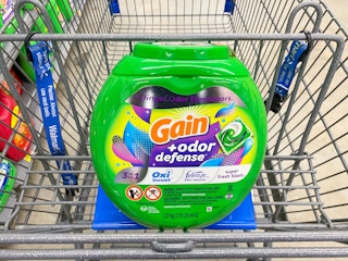 A bottle of Gain Flings Laundry Detergent in a Walmart shopping cart
