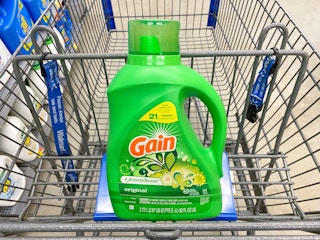 A bottle of Gain Liquid Laundry Detergent in a Walmart shopping cart