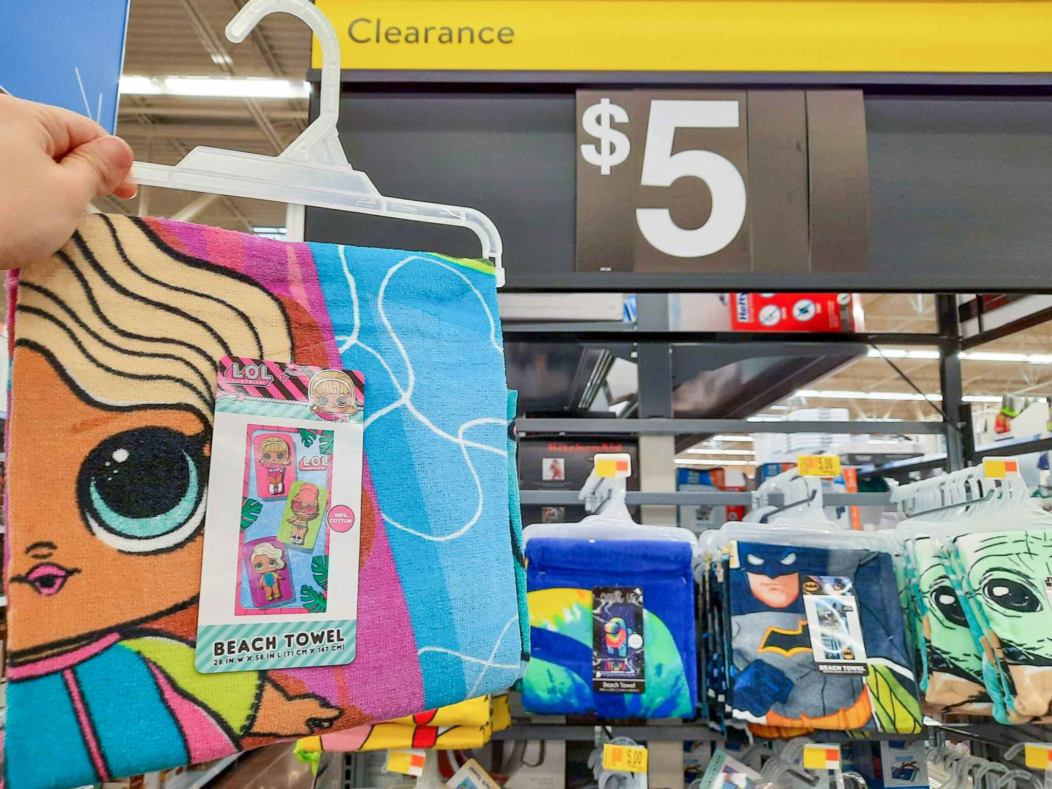 LOL Surprise Beach Towel held in front of $5 clearance sign.