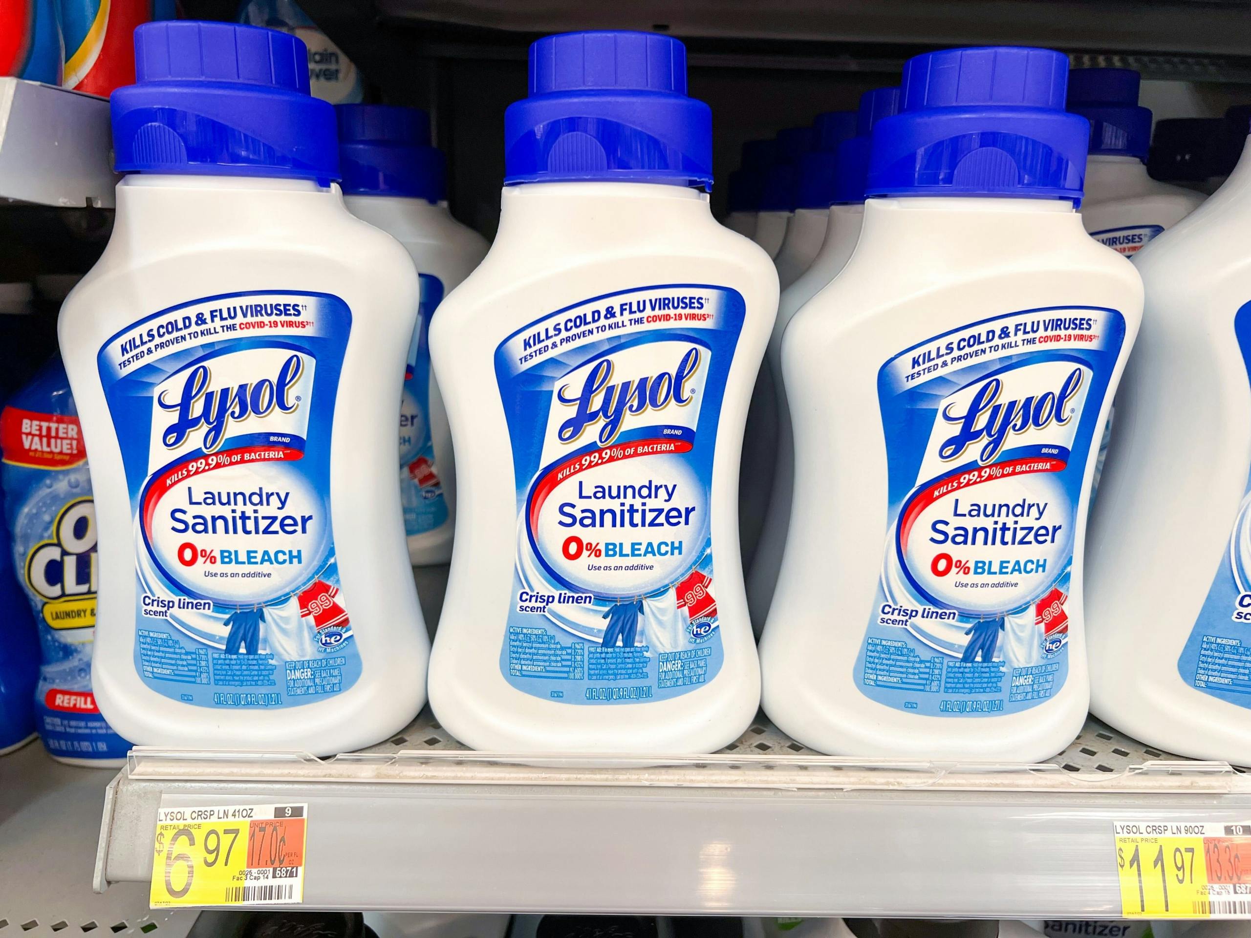 three bottles of Lysol laundry sanitizer on a Walmart shelf with the price tag showing