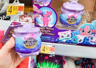 Magic Mixies Mixlings Collectors Cauldron held in front of shelf at Walmart. Price tag on shelf indicates that the price is $4.97.