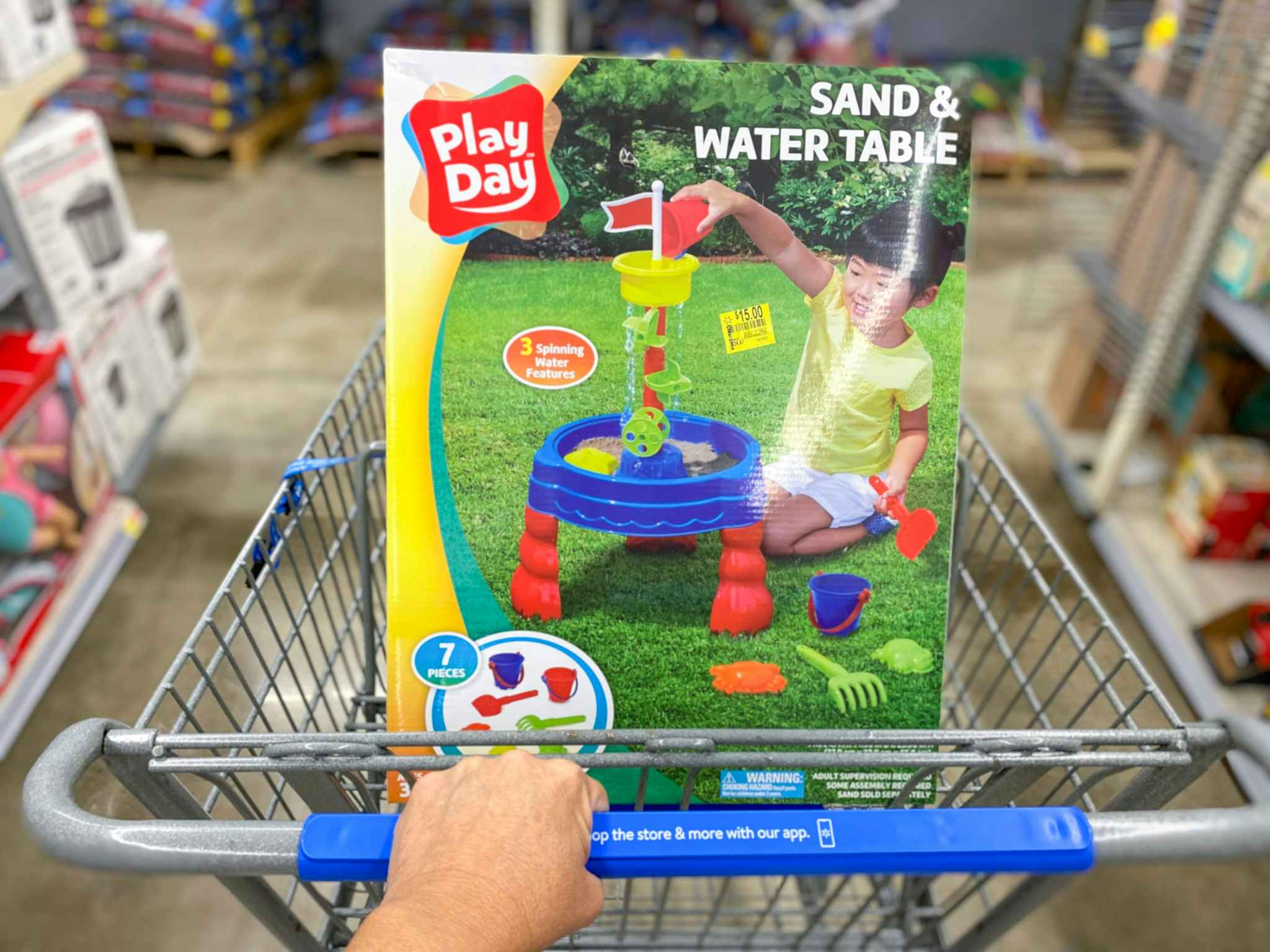 hand pushing walmart cart with play day sand and water table