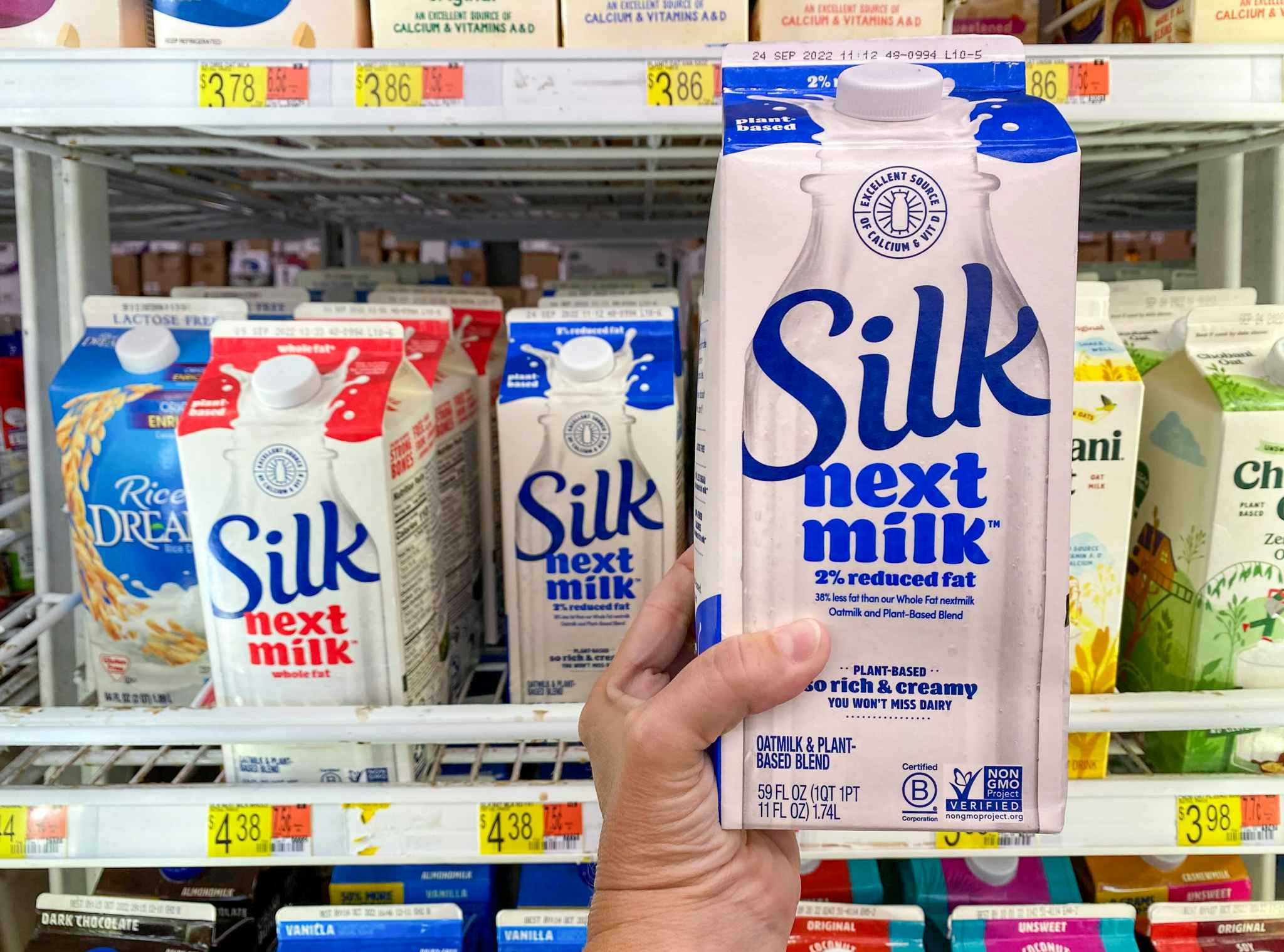 Hand holding Silk Next Milk in front of shelf at Walmart