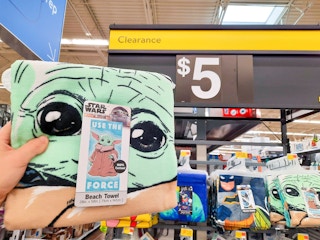 Star Wars Beach Towel held in front of $5 clearance sign.