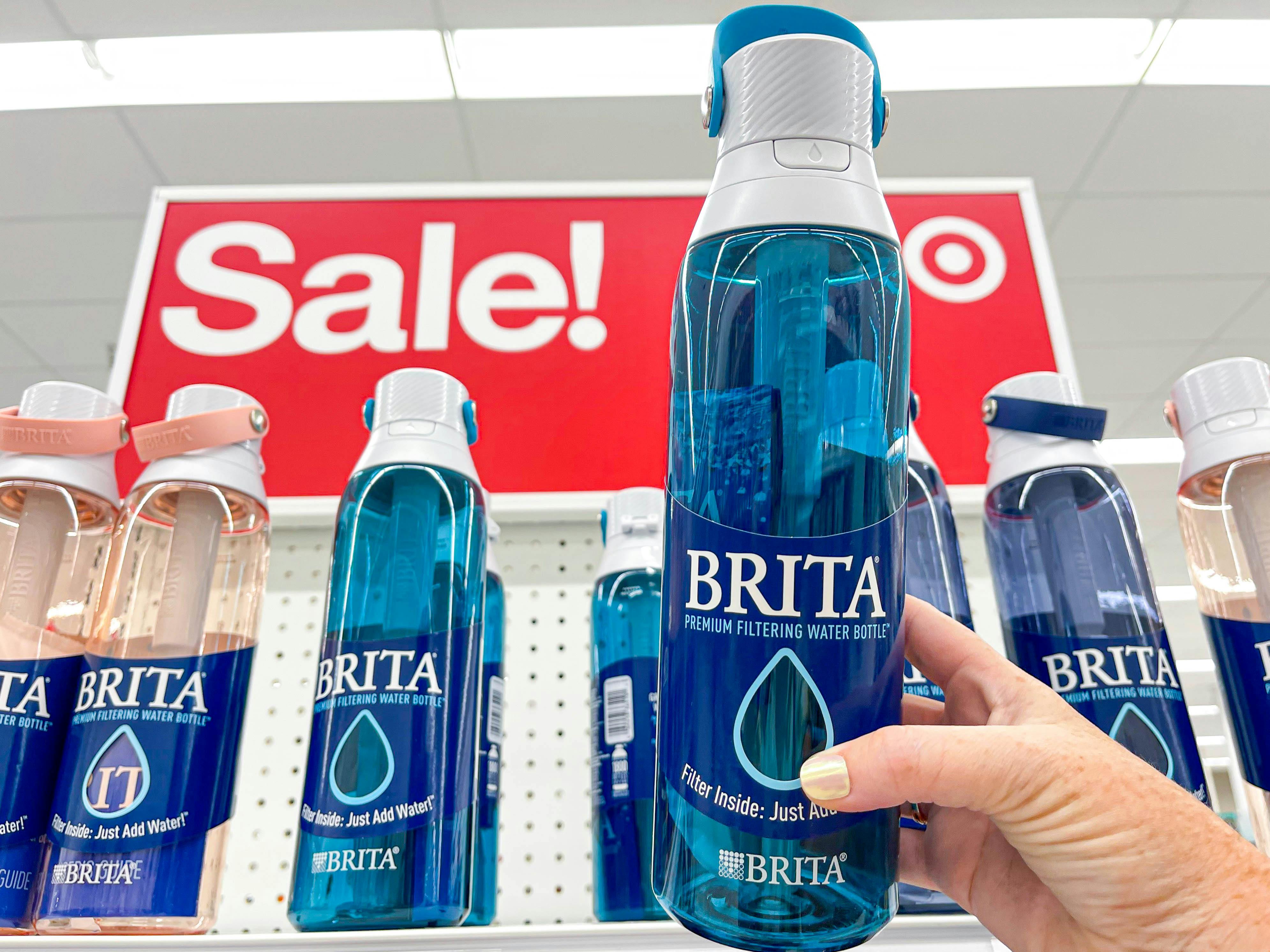 brita filter water bottles on shelf in front of sale sign with one being held