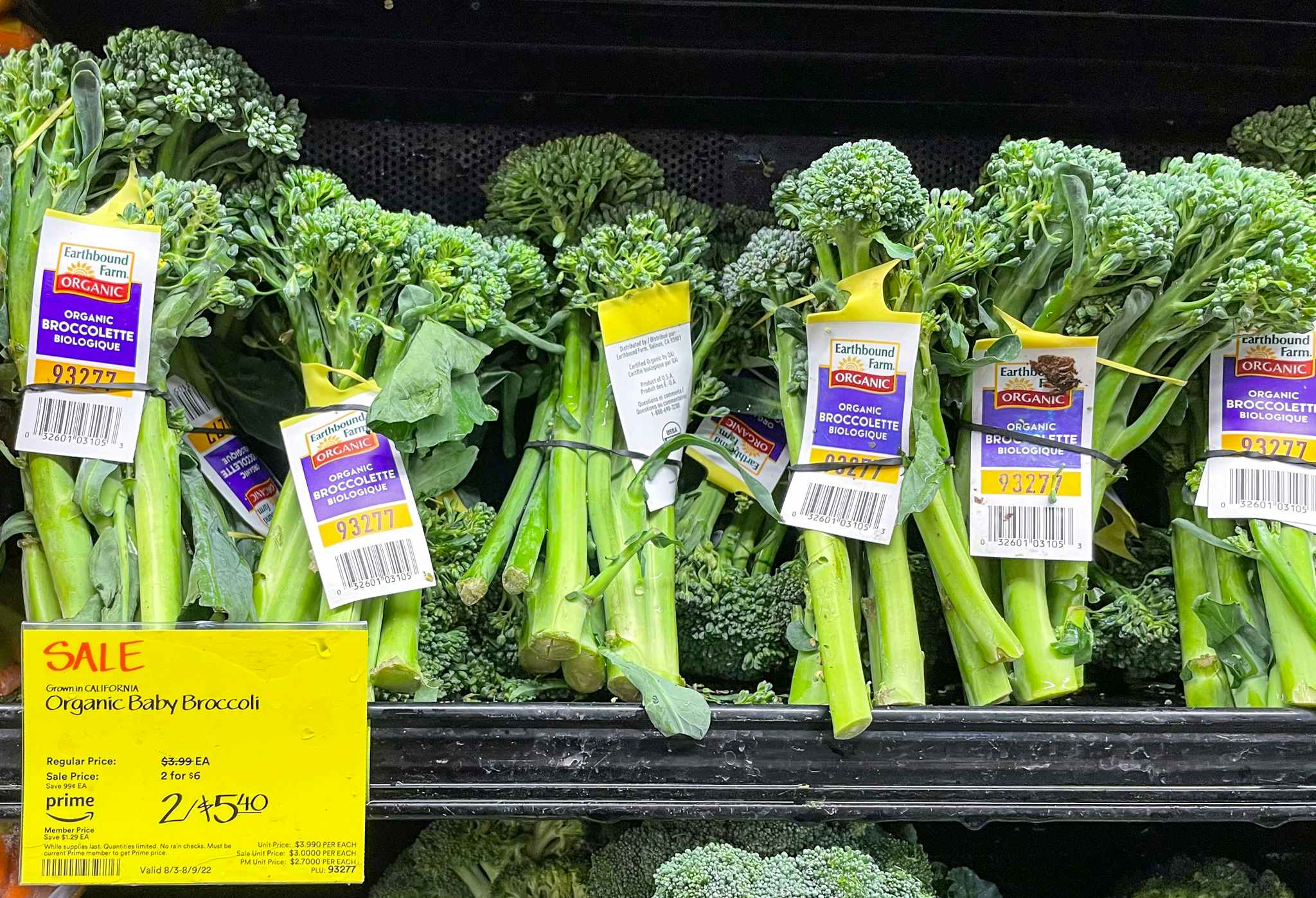 baby broccoli bunch on a shelf with sales sign at whole foods