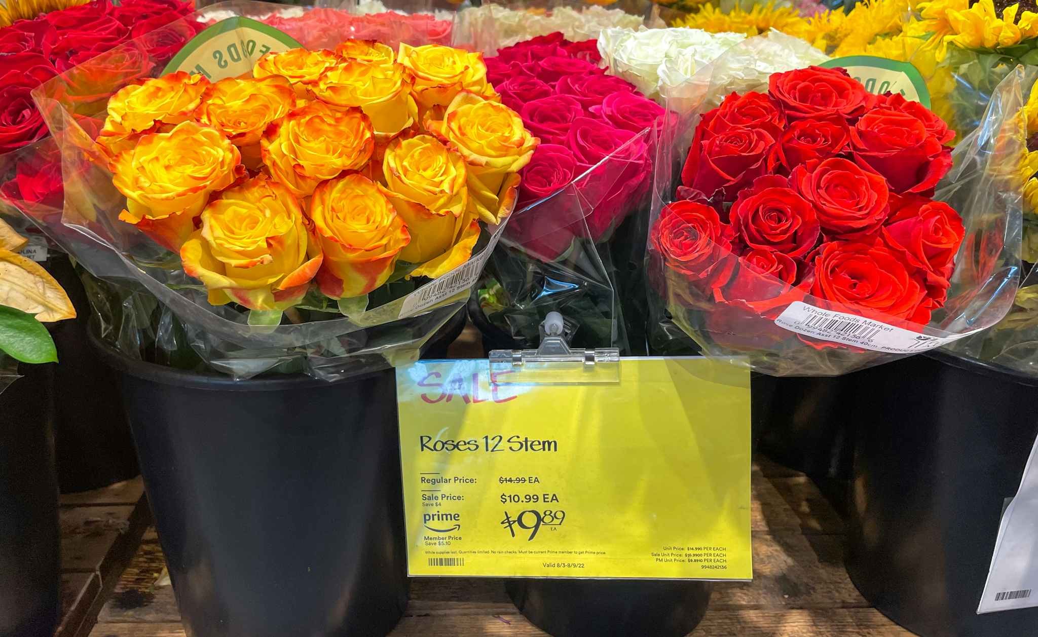 roses in a bucket with sales sign at whole foods