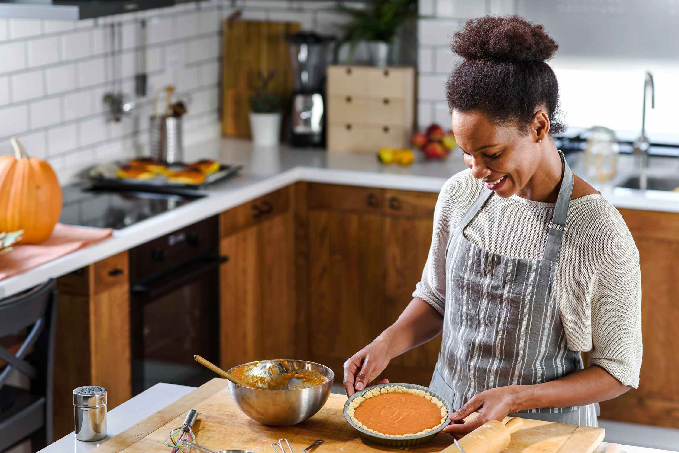 woman in kitchen baking holiday pumpkin pie