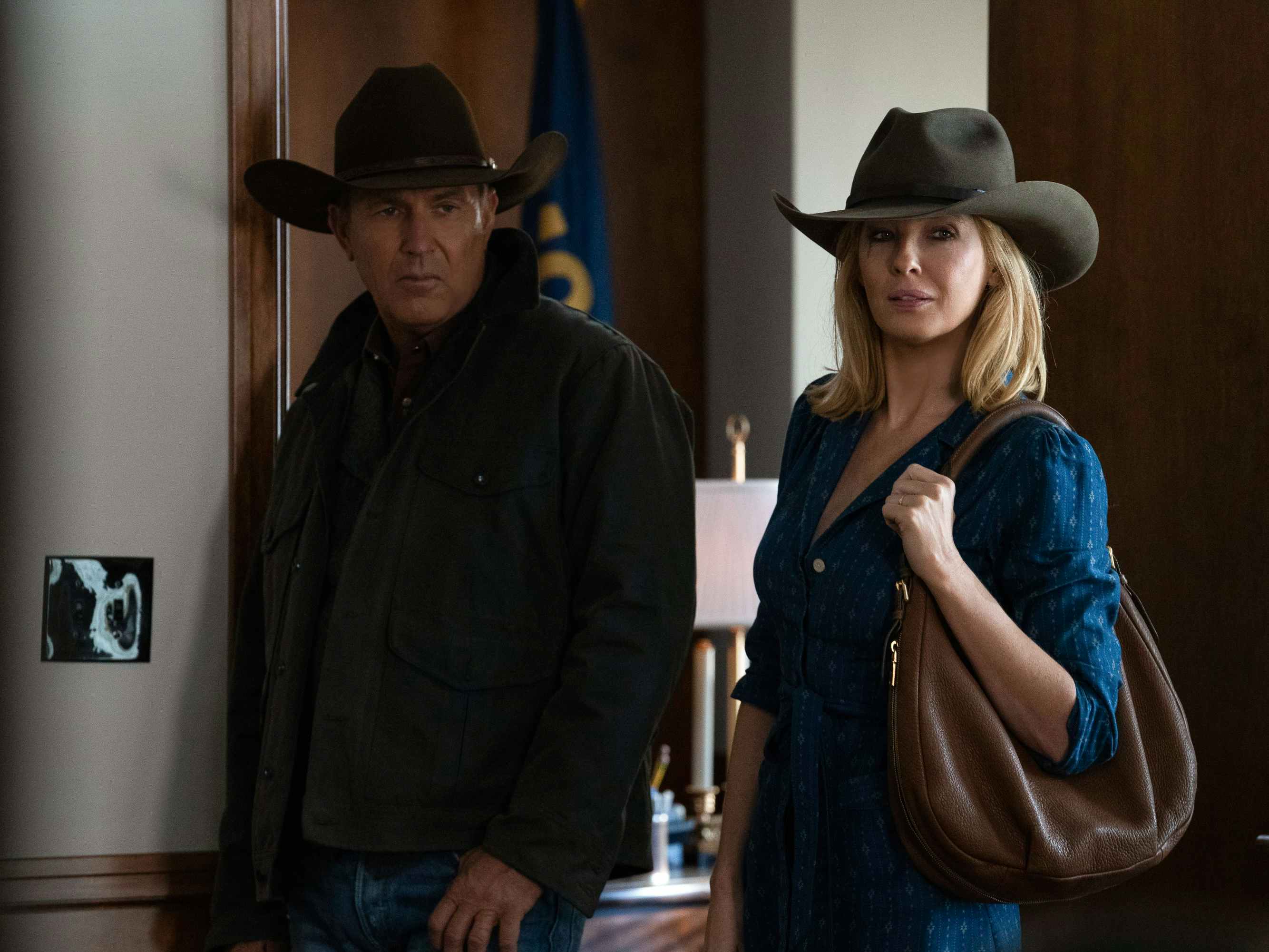 A still from an episode of Yellowstone with two cast members standing in a doorway.