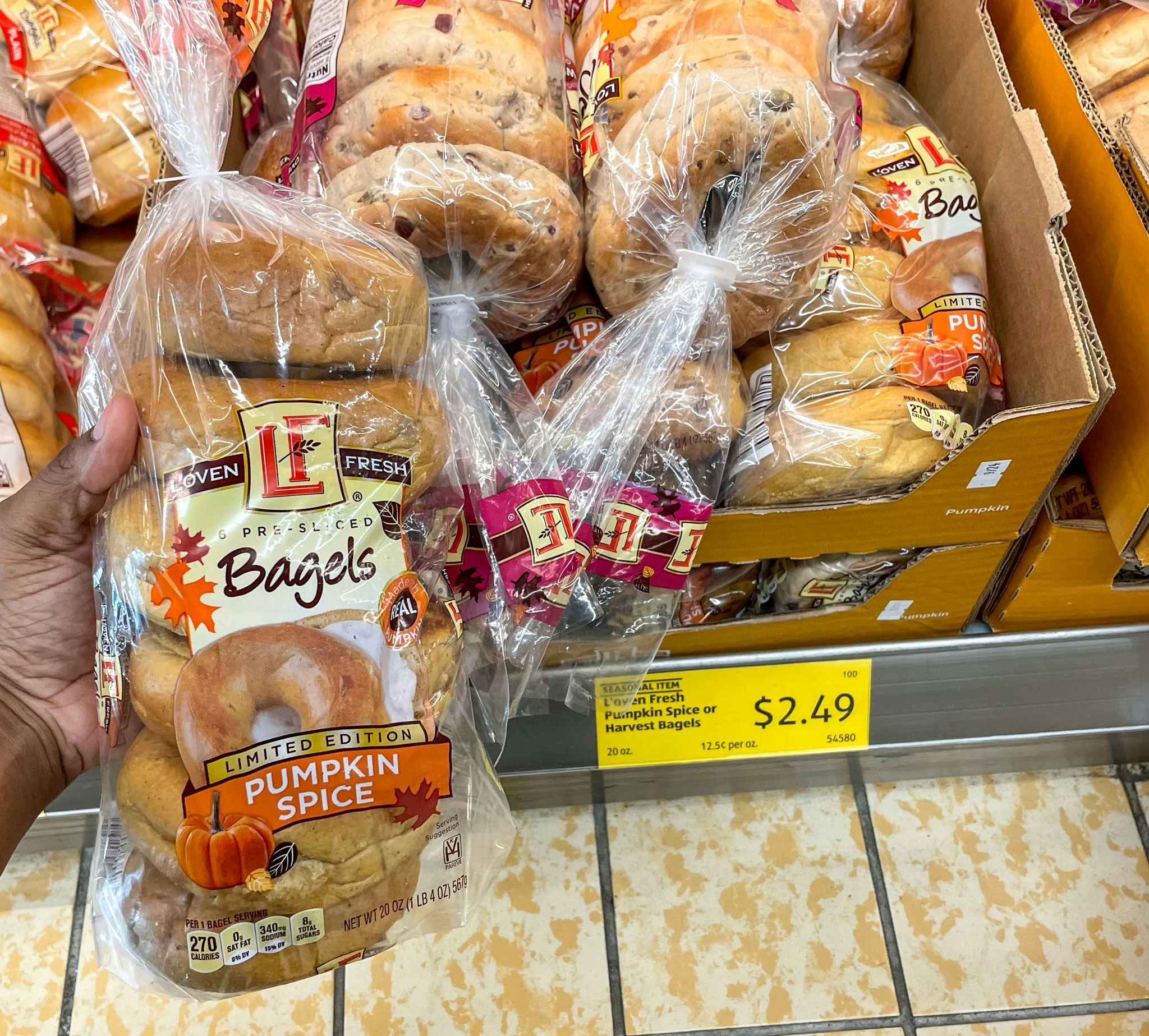 bagel hand held near sale sign at aldi